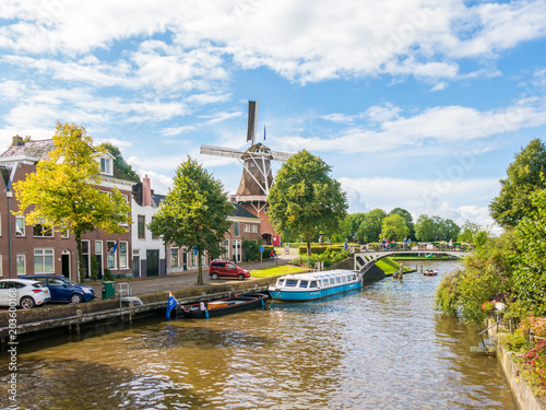 Windmill and bridge over canal in historic old town of Dokkum, Friesland, Netherlands