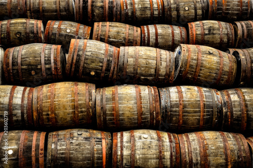 Foto Stacked pile of old whisky and wine wooden barrels