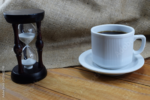 coffee time, coffee mug and an hourglass on the table
