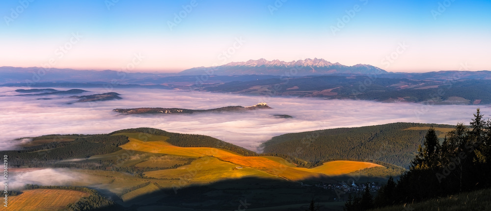 Fototapeta premium Panoramic landscape view of meadows, castle and mountain range, Slovakia