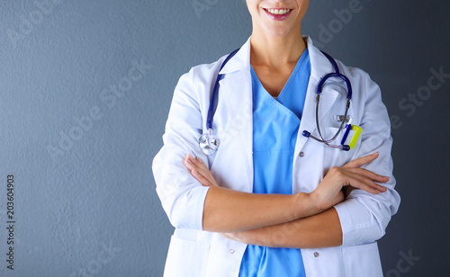 Canvas-taulu Portrait of young woman doctor with white coat standing in hospital