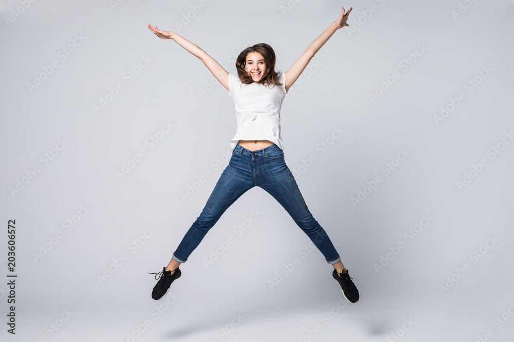 I did it. Dreams come true. Concept of freedom, happiness and life without problems. Vertical full length portrait of happy crazy woman is jumping up, isolated on grey background