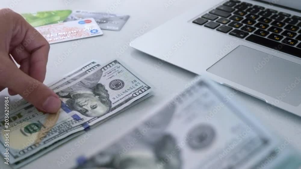 Hands Counting Money. Dollar bills, money background. Hands flipping through a stack of US dollar bills with a large stack of hundred US dollar bills on background. Hands Counting Money. Dollar bills, money background. Hands flipping through a stack of US dollar bills with a large stack of hundred US dollar bills on background.