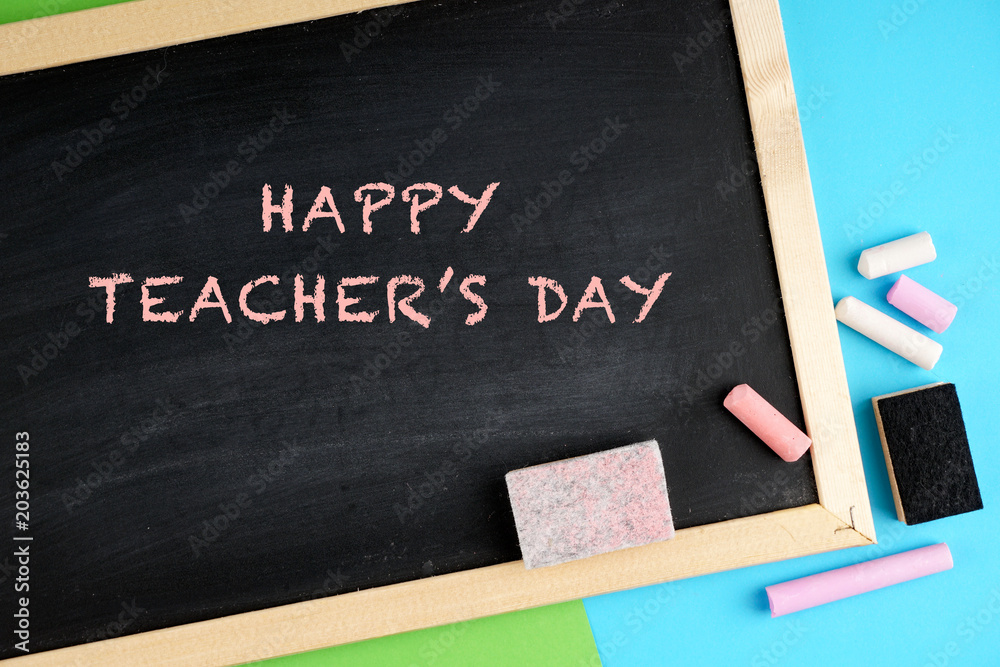 Happy teacher's day concept with a black board, chalks, note book, pen Happy teacher's day concept with a black board, chalks, note book, pen