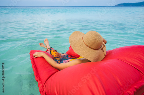 Young woman relaxing and enjoying with float mattress at the tropical beach