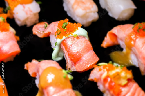 Sushi Set Sashimi and sushi rolls served on black stone slate.Close Up.