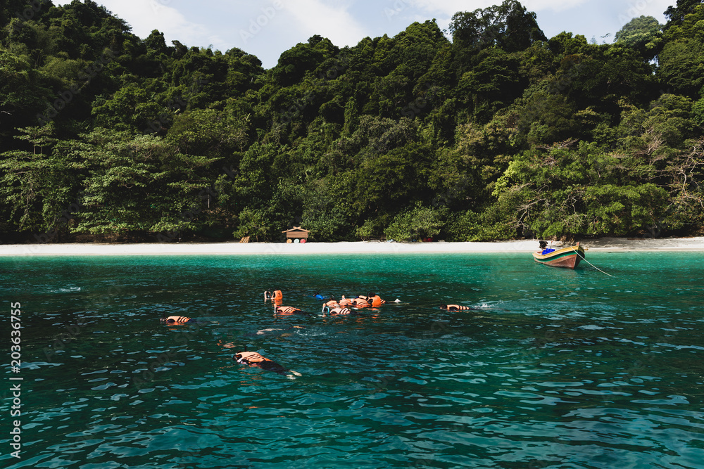 Obraz premium Cinematic color group of tourist doing snorkeling at Flower Island