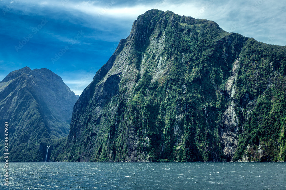 Rocky mountains and waterfall in Milford sound, image taken from cruise ferry