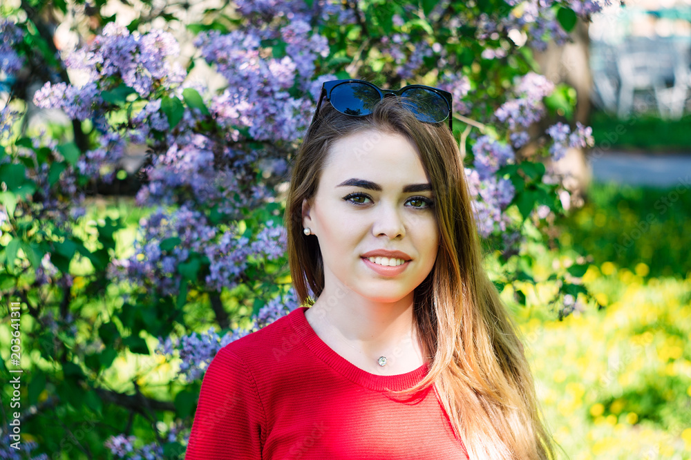 Young beautiful girl in the spring time near the flower