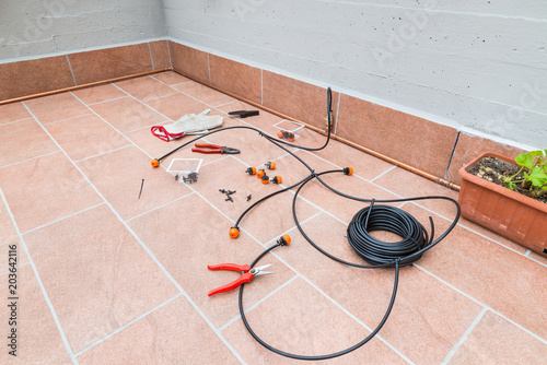 Accessories and materials for completing a micro drip irrigation system for potted plants on terrace, for to conserve and save water and time, (orange drippers, goof plugs, flexible micro tubing)