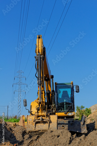 Canvas Print Excavator working near power lines