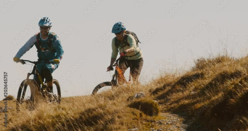 Front view close-up of friends having an adventure on mountain bikes. Front view close-up of friends having an adventure on mountain bikes.