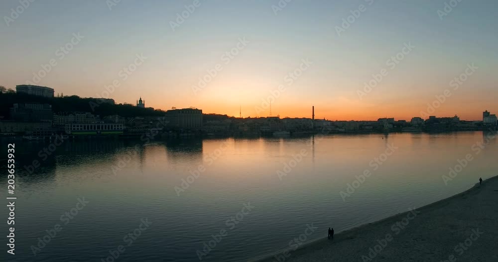 Aerial video at sunset with view of city, reflection,forest and river.Flying above the lake and revealing the bridge.Sunset Light blue and golden hour bridge and river. Top view on bridge on sunset. Aerial video at sunset with view of city, reflection,forest and river.Flying above the lake and revealing the bridge.Sunset Light blue and golden hour bridge and river. Top view on bridge on sunset.