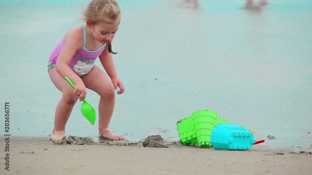 Little girl with brother are building a sand castles on the beach Little girl with brother are building a sand castles on the beach