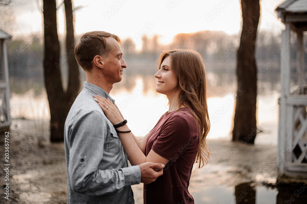 Couple in love watching each other eyes on the background of beautiful lake