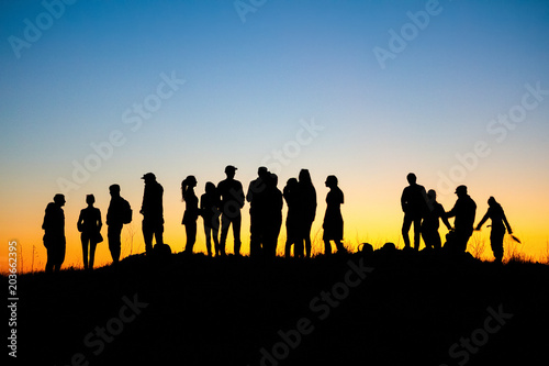 People silhouettes against the twilight sky