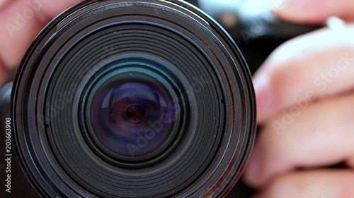 Detail of focus of the camera lens with press the shutter release button, front view. Gradually zooming the lens, close-up. photo