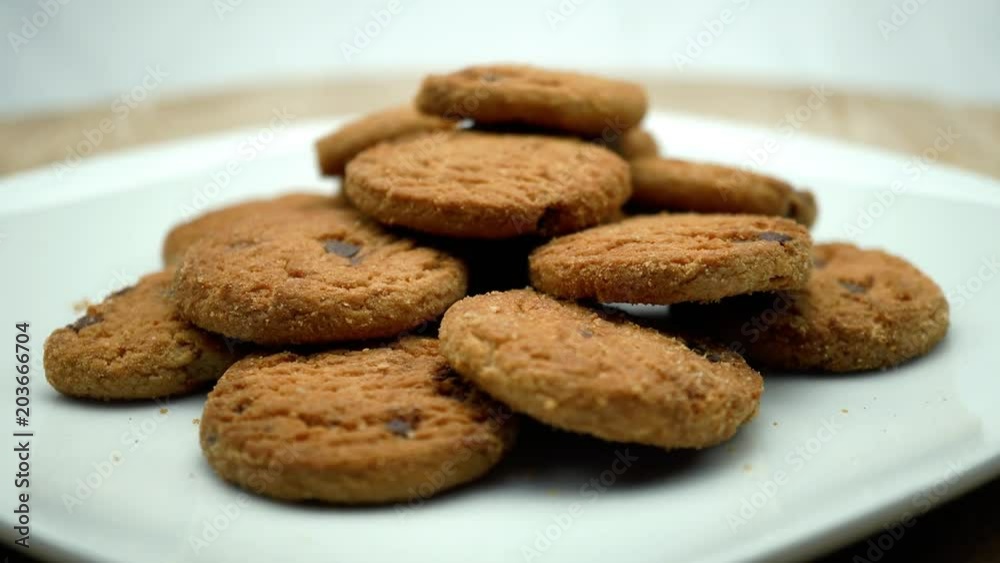 Fresh cookies on the plate. On a rotating white background. Wooden table. 4K Fresh cookies on the plate. On a rotating white background. Wooden table. 4K
