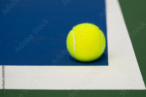 Tennis ball on a blue tennis court © bignai