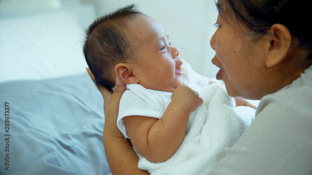 Little baby enjoy with grandmother in bedroom