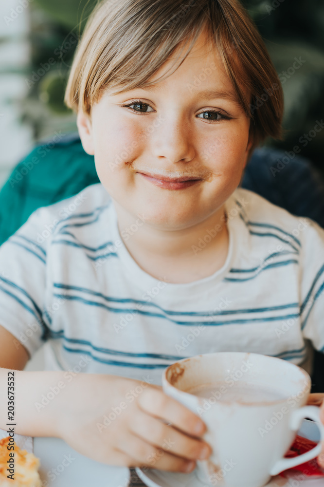 Funny little boy drinking hot chocolate for breakfast Funny little boy drinking hot chocolate for breakfast