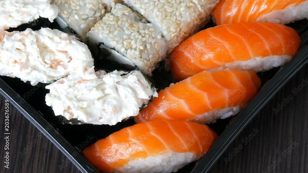 Camera moves right. Great choice Variety of sushi roll, nigiri, maki, Gunkan with salmon, eel, shrimps, Philadelphia cheese and other national Japanese cuisine close up Camera moves right. Great choice Variety of sushi roll, nigiri, maki, Gunkan with salmon, eel, shrimps, Philadelphia cheese and other national Japanese cuisine close up