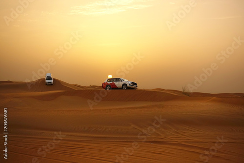 Adventure desert safari on sand dunes with off road vehicles at sunset 