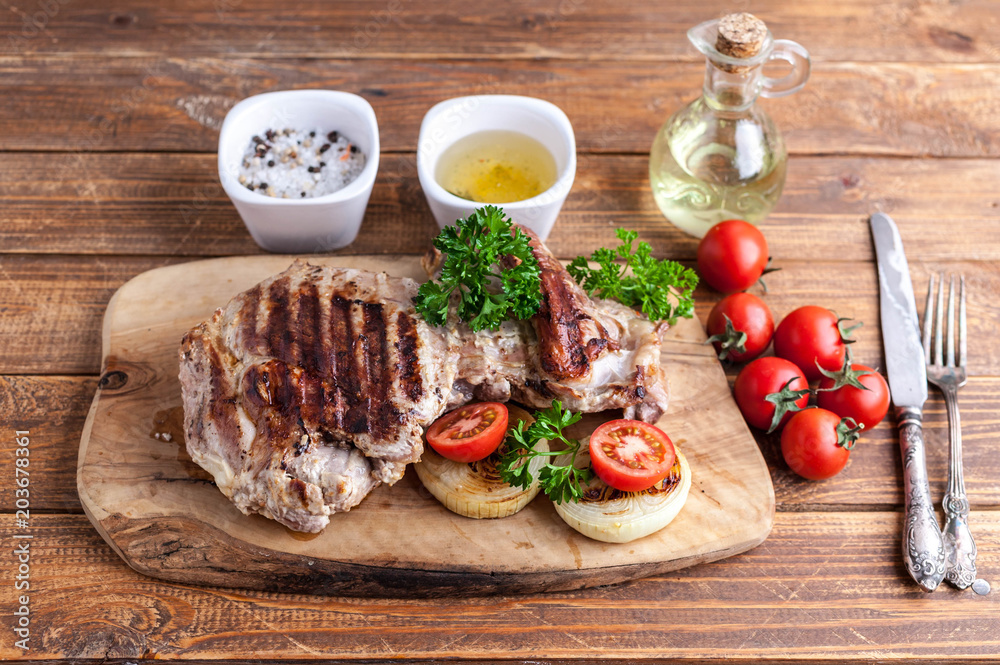 Grilled turkey fillet with spices, herbs and cherry tomatoes on a cutting board. Grilled turkey fillet with spices, herbs and cherry tomatoes on a cutting board.