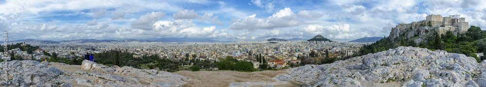 Panoramic view of Athens city, Greece from the National Observatory of Athens (left) to Acropolis (right). Vantage point of Areopagus hill in Plaka. Sunny day with cloudy blue sky