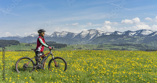 Fototapeta Naklejka Na Ścianę i Meble -  Seniorin mit dem Mountainbike im Bergfrühling im Allgäu, bayern,Deutschland