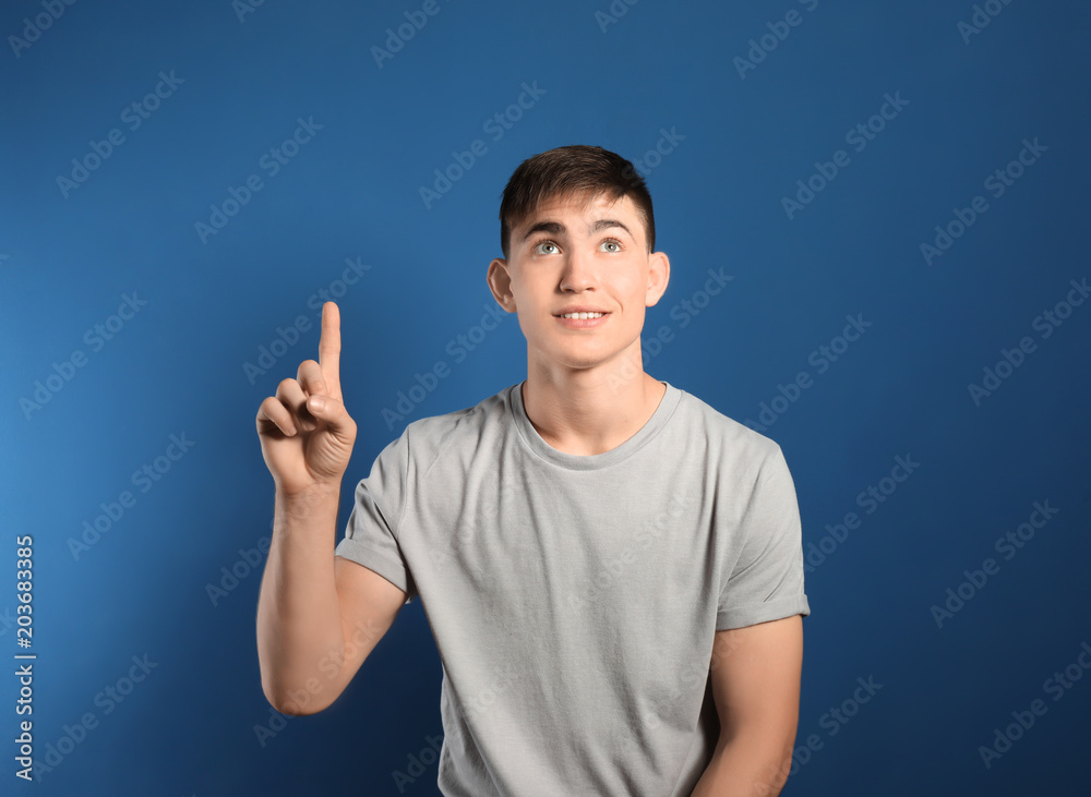 Portrait of teenage boy showing eureka sign on color background Portrait of teenage boy showing eureka sign on color background