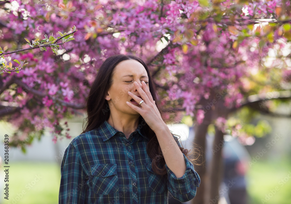 Woman sneezing because of spring pollen allergy Woman sneezing because of spring pollen allergy