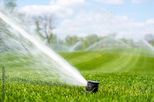 irrigation system sprinkles water fountain for long distance irrigated golf course photo
