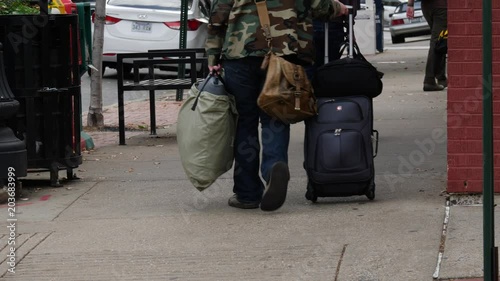 Tourist carrying a bag and pulling a suitcase