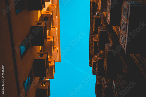 low angle view between two houses in orange colors and copy space in the center photo