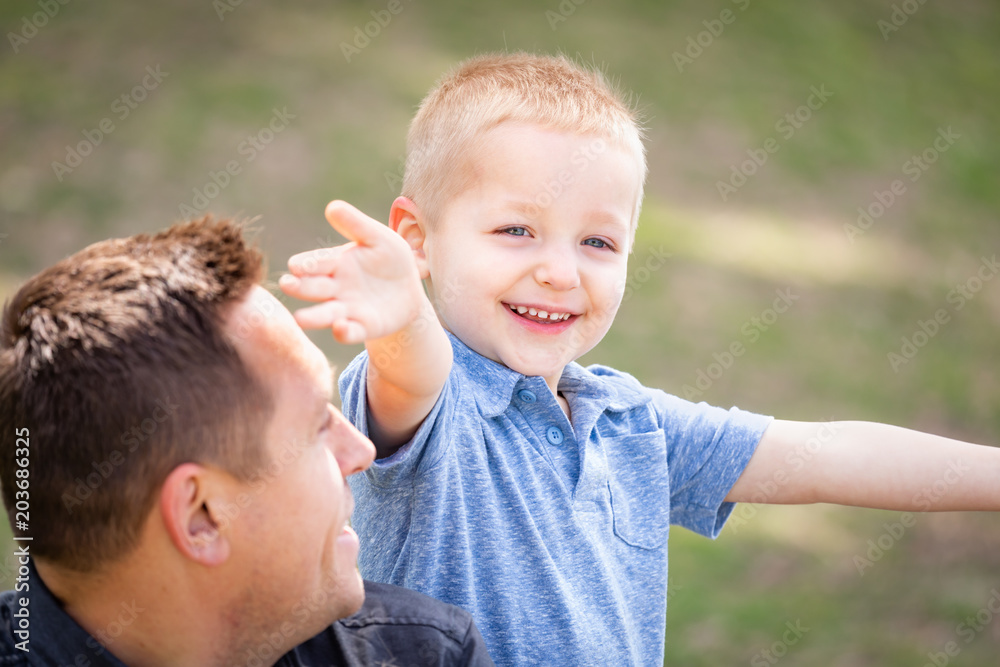 Young Caucasian Father and Son Having Fun At The Park Young Caucasian Father and Son Having Fun At The Park