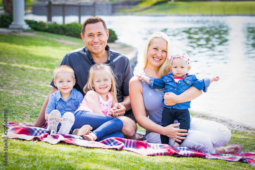 Happy Young Caucasian Family Portrait In The Park Happy Young Caucasian Family Portrait In The Park