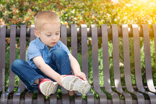 Young Boy Sitting On A Benc...