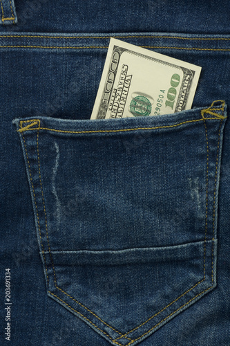 Dollars in jeans pocket. One hundred bills. Bundle of dollars