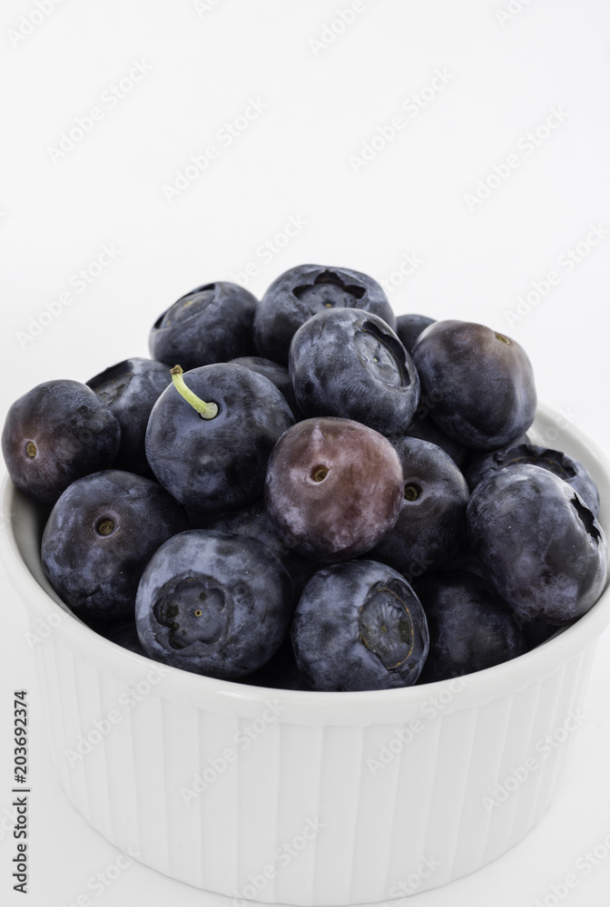 Small White Bowl Filled with Ripe Blueberries, White Background Small White Bowl Filled with Ripe Blueberries, White Background