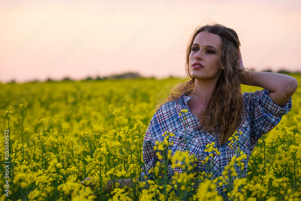 Happy young woman in a field of canola seed in bloom. Freedom, nature, ecology and happiness concept. Happy young woman in a field of canola seed in bloom. Freedom, nature, ecology and happiness concept.