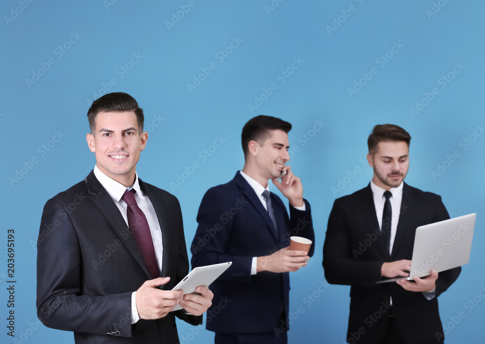 Men in elegant suits on color background Men in elegant suits on color background