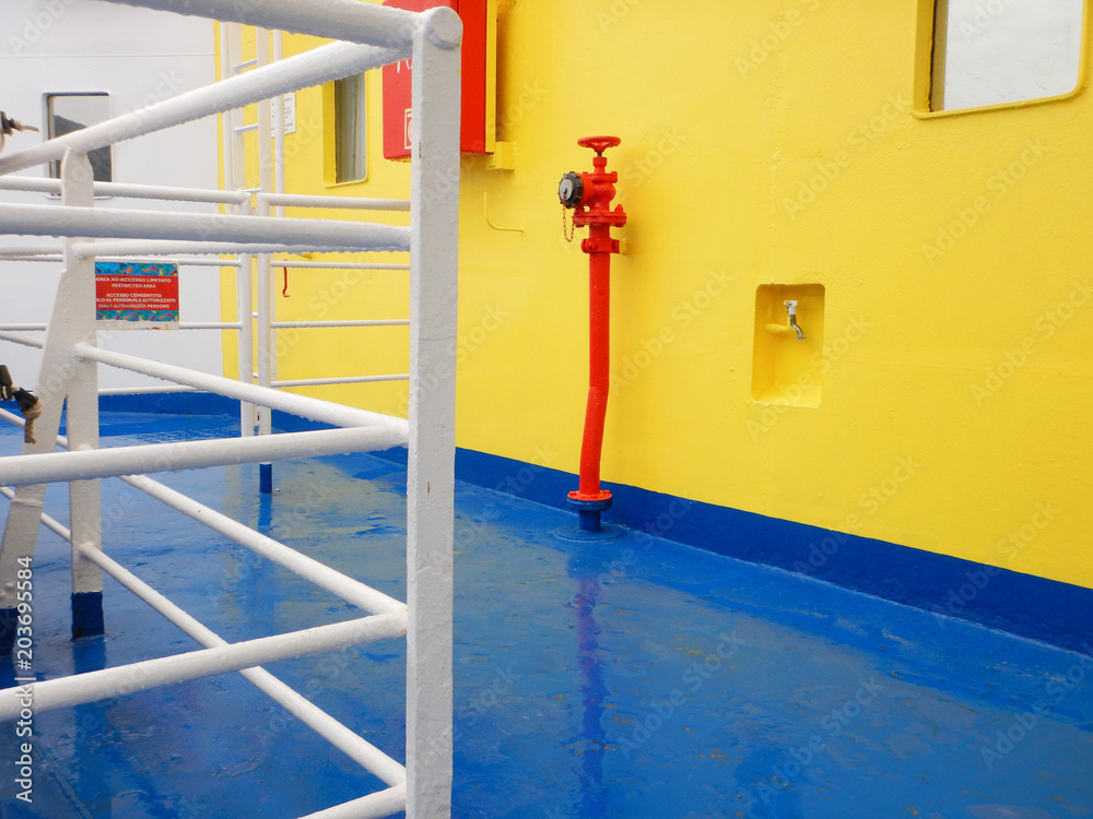 Naklejka premium red fire hose connection on ferry boat deck