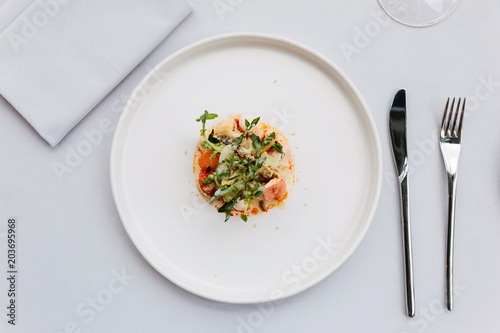 Modern French cuisine: Top view of lobster tail salad including lobster, asparagus and roasted sunflower seeds with white sauce served in white plate.