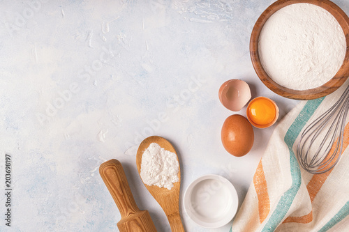 Ingredients for baking  - flour, wooden spoon, eggs.