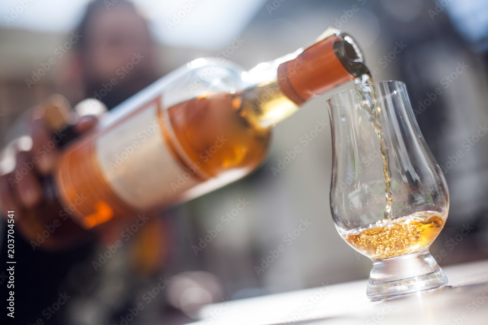 Pouring whisky in a glass foto de Stock | Adobe Stock