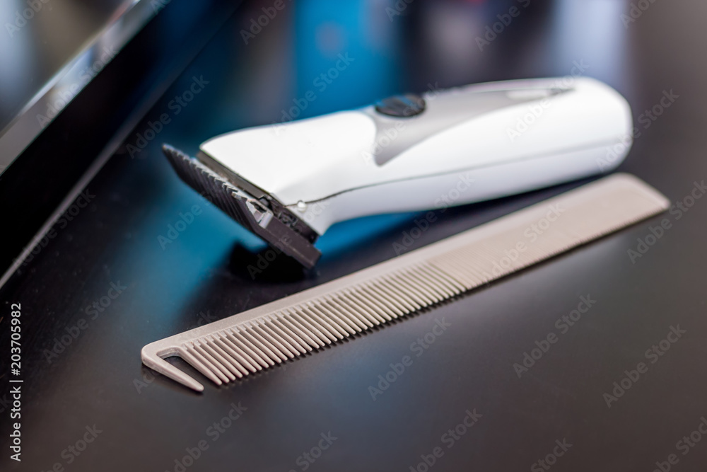 Comb and a haircut machine in barbershop on master's table_ Comb and a haircut machine in barbershop on master's table_