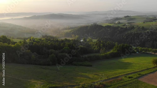 Sunrise over misty hills in Brusnik,Poland with lookout tower. Aerial fly backwards. photo