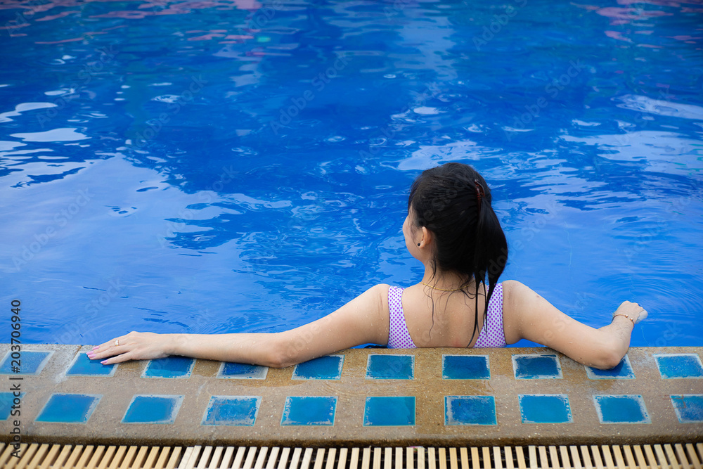 Woman relaxing at the swimming pool