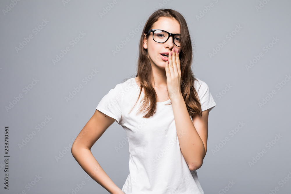 Portrait of a tired sleepy girl yawning isolated on a gray background Portrait of a tired sleepy girl yawning isolated on a gray background